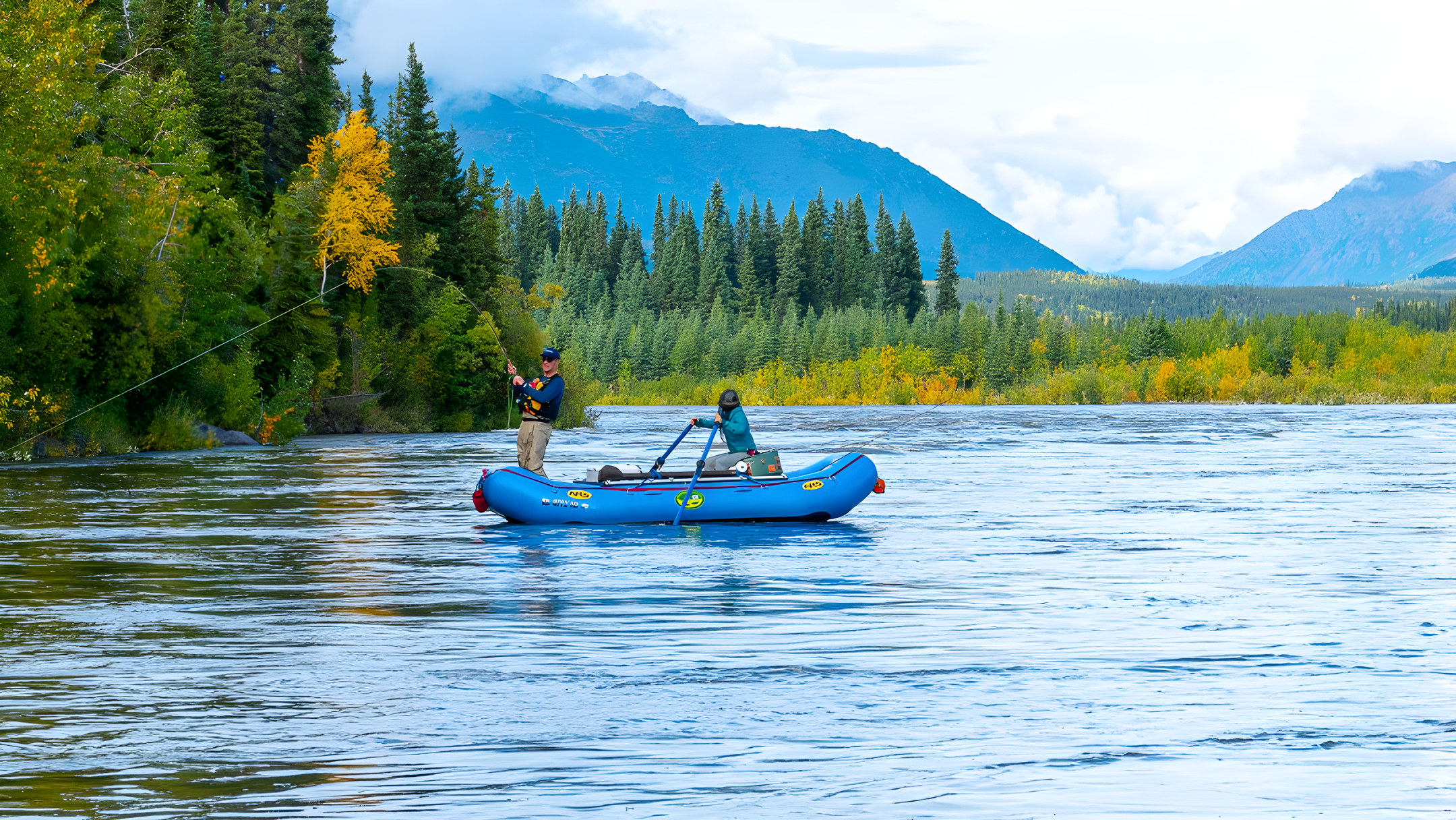 A guide and angler fish from an inflatable raft on the Kobuk River, surrounded by autumn tundra and the Brooks Range.